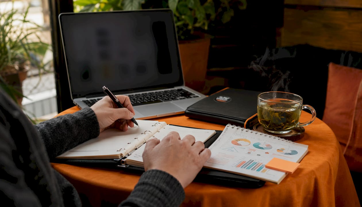 Hands calculating marketing KPIs at desk