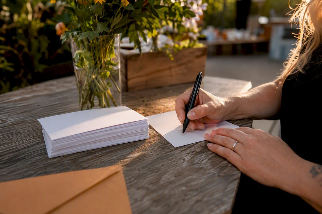 Hands placing thank-you card in envelope