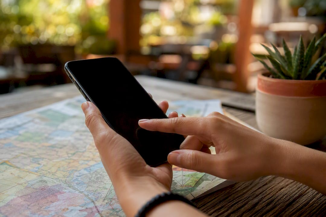 Hand holding smartphone for location targeting